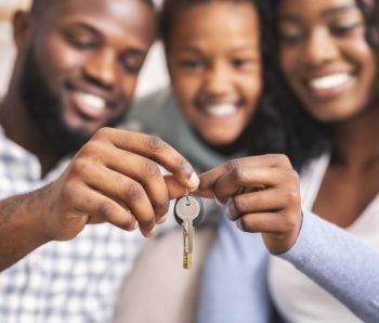 Happy african american family holding keys from their new home