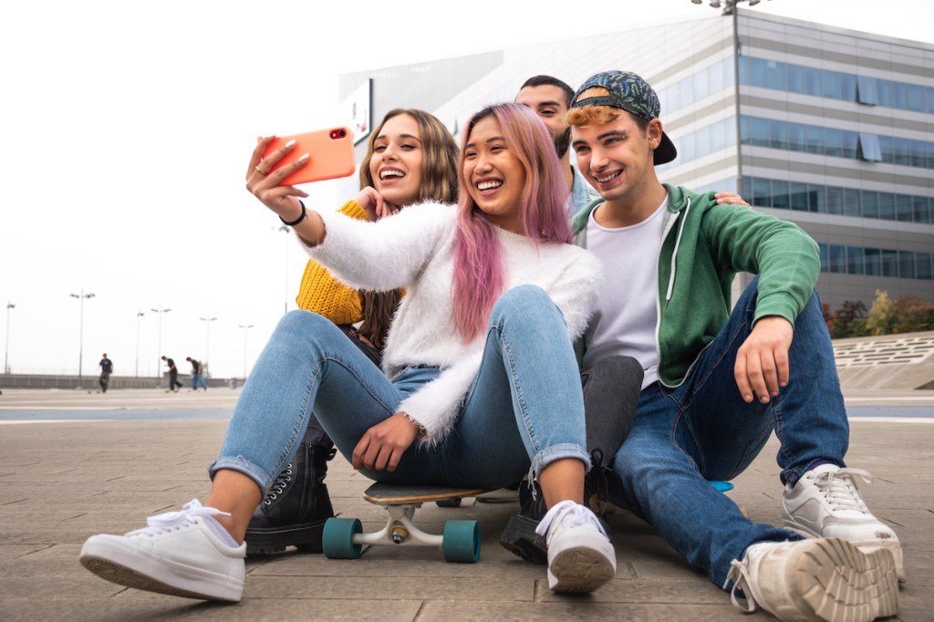 Happy group of friends takes a selfie outdoor.