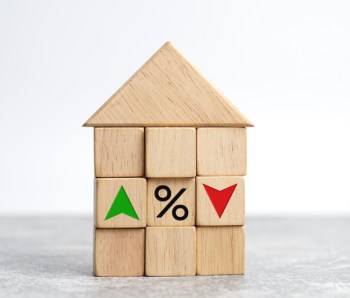 Interest rate financial and mortgage rates concept. house and real estate. Wooden cube block with icon percentage, symbol arrow up and down.